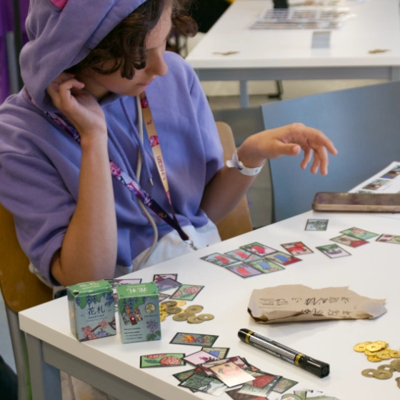 Osoba ucząca się hanafudy przy stoliku na Hikari