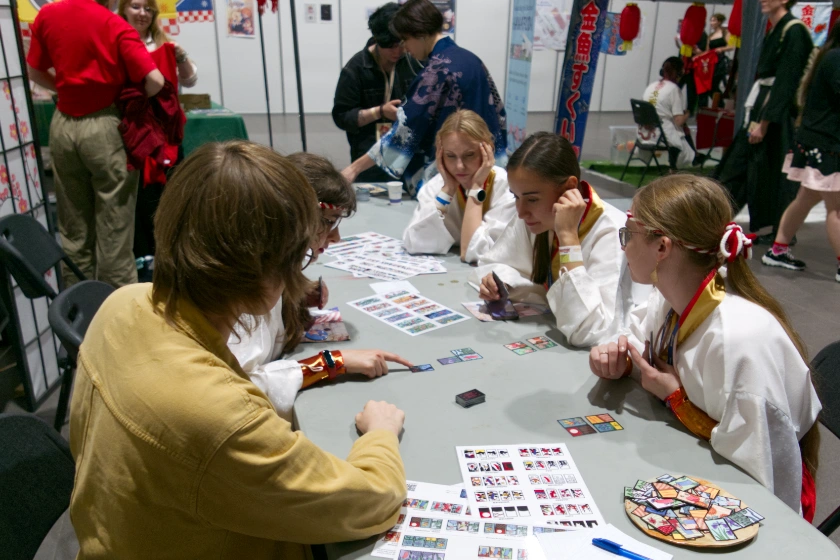 Osoby przy stole uczące się hanafudy na Animatsuri