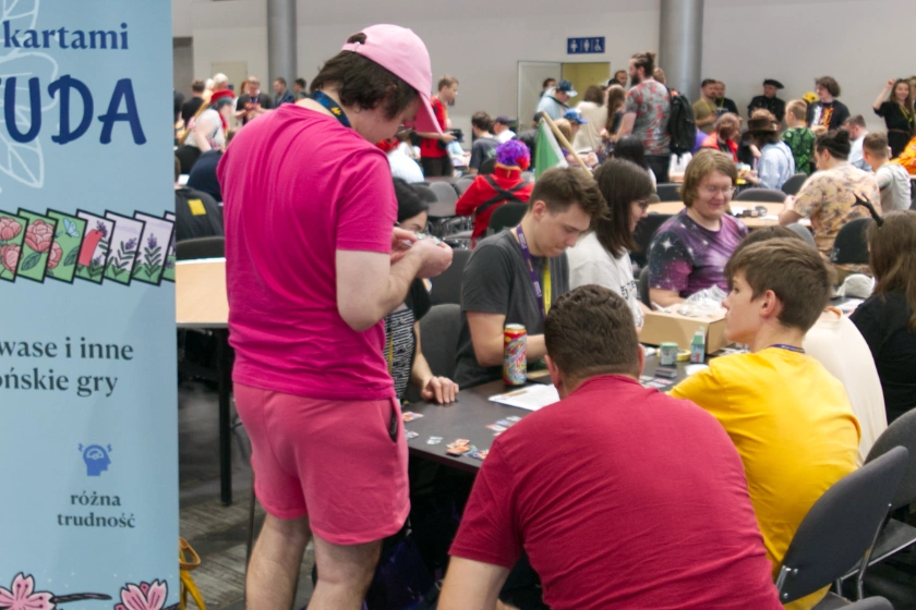 Osoby przy stole uczące się hanafudy na Pyrkonie